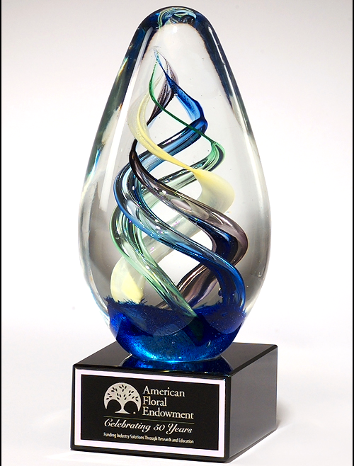 Egg-shaped art glass award on black glass base